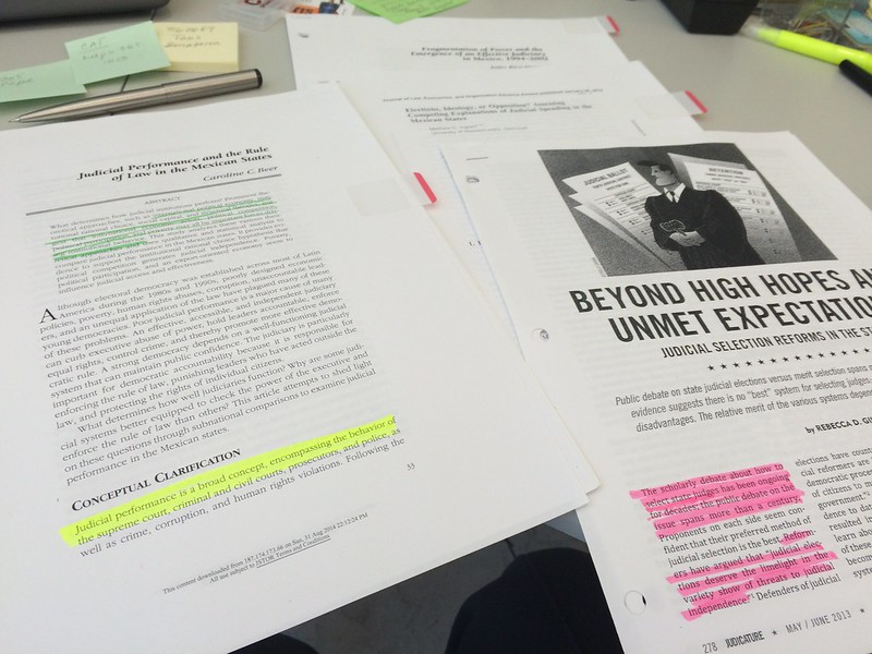 Research sources spread out on a table, showing highlighted passages