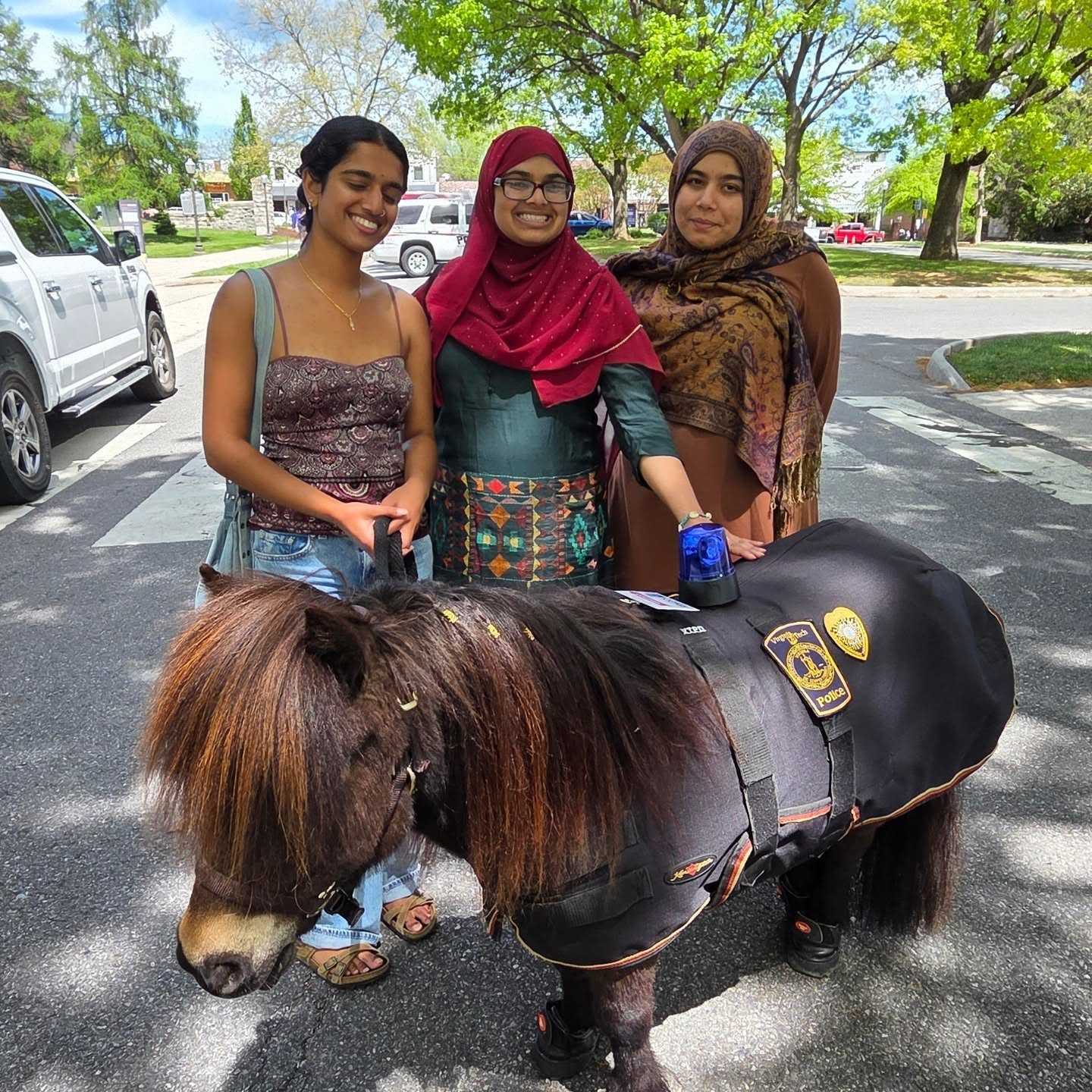 A photo of three women with Ringo the Patrol Pony from the International Street Festival
